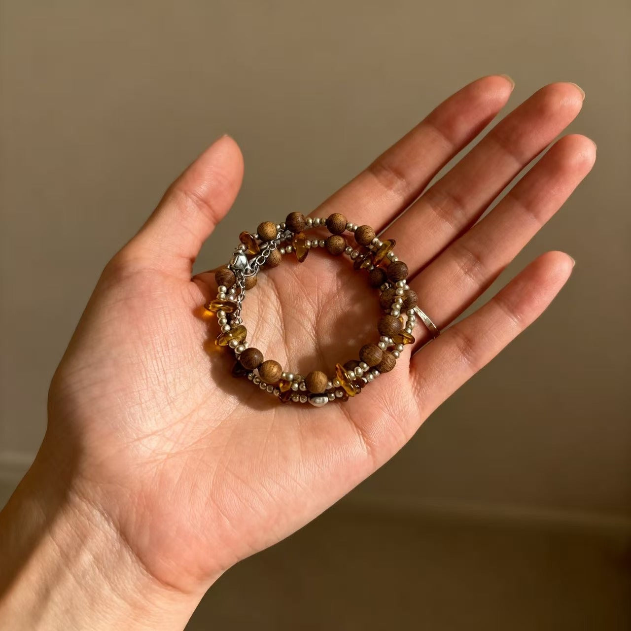 A delicate harmony of natural agarwood and warm amber-inspired stone accents.