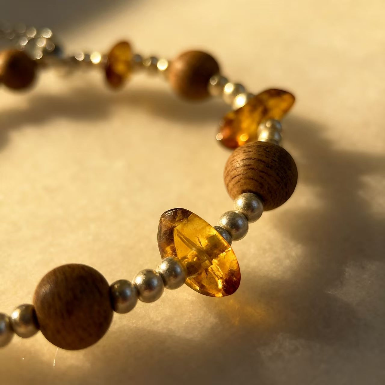 A delicate harmony of natural agarwood and warm amber-inspired stone accents.